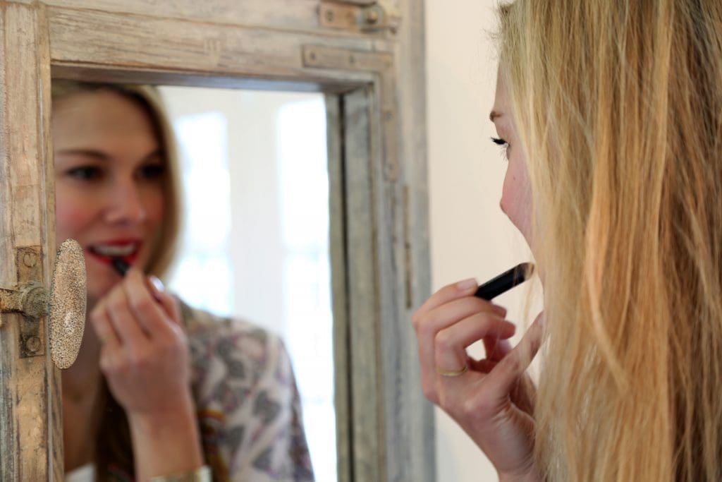 Lee applies her signature red lip. 
