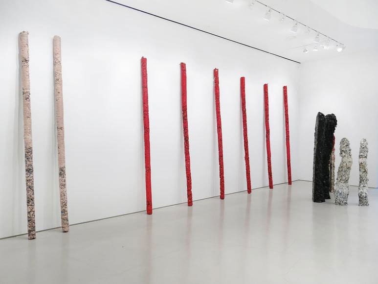 Approximately 200 resin-and-pigment totems stand like ghostly presences.  