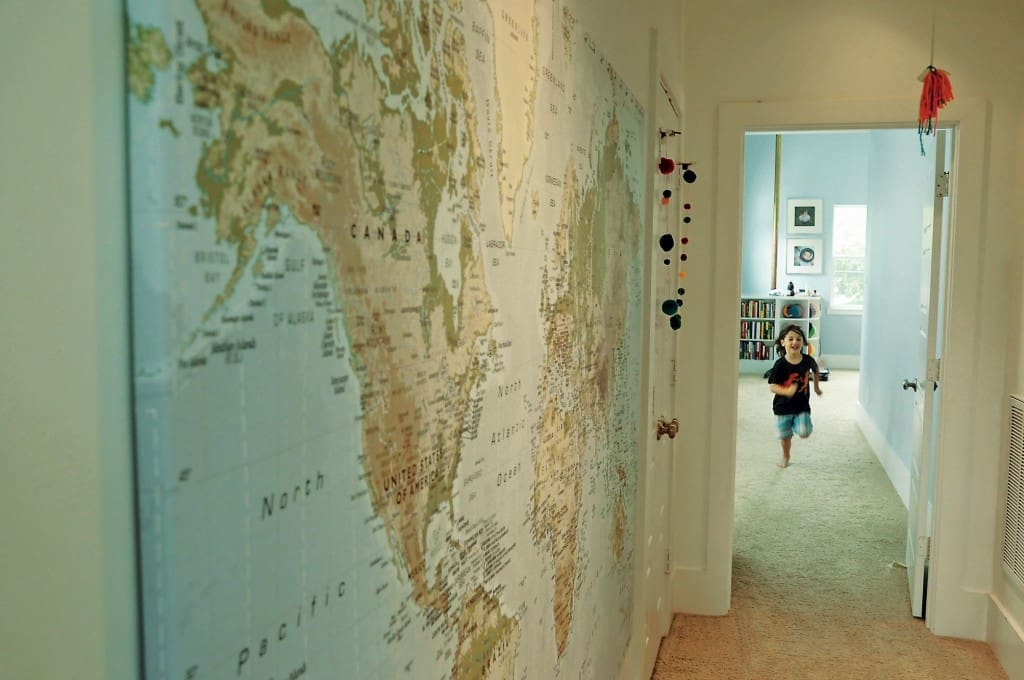 Large wall map from IKEA shows where the family lives and travels. The children made the yarn baubles.