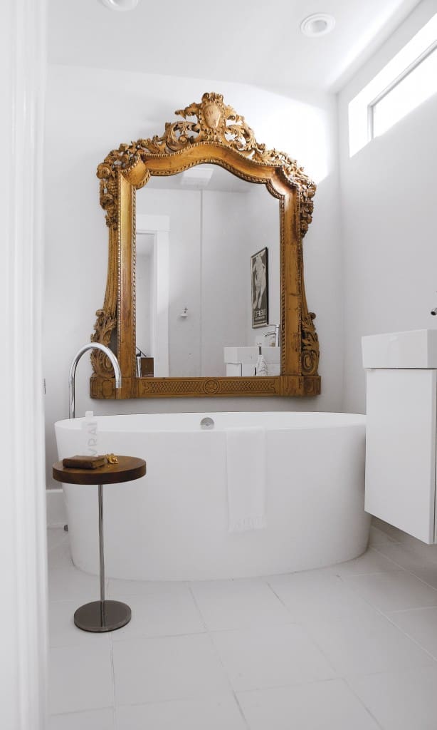 The master bath is all about sculpture, beginning with the imposing Victoria & Albert-era mirror from Kuhl-Linscomb. Tub from Westheimer Plumbing, sink and cabinet IKEA. Ligne Roset table provides the final chic motif.