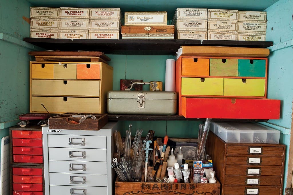 Tools, drawers and her dad’s cigar boxes line a work cabinet.