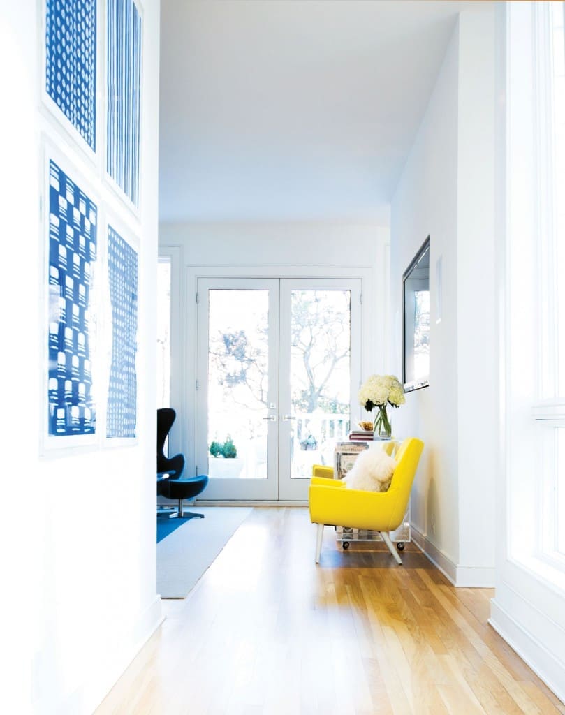 The yellow chair by Jonathan Adler provides cheerful contrast to the den’s gray palette.