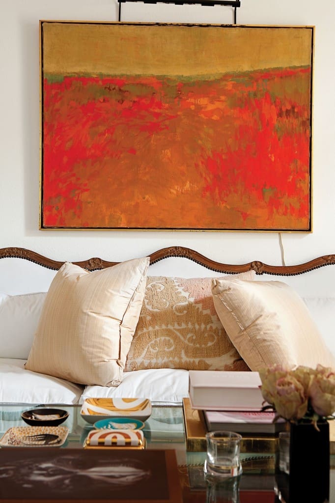 In the salon, an oil painting from the estate of Herb Wells hangs above an 18th-century French Louis XIV sofa from James Powell, Austin, covered in white cotton. Pillows in pink strie silk by Rose Tarlow from George Cameron Nash. Vintage textile pillow from Thompson Hanson. Wayland Gregory porcelain ashtrays and box from Sloan/Hall.