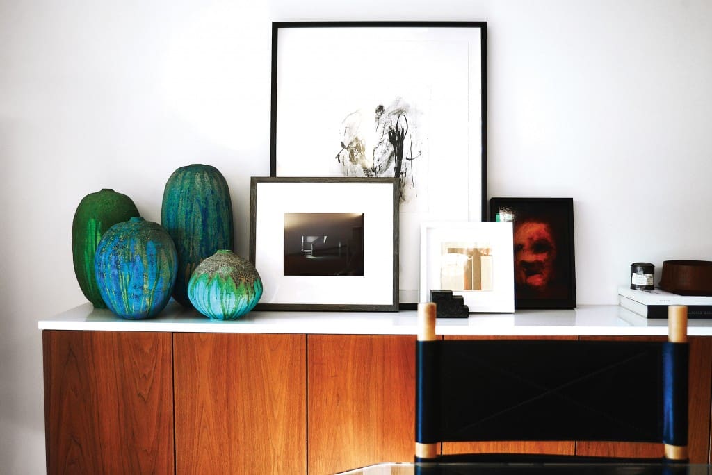 Joshua Rice: Vintage pottery by ceramicist Richard Lincoln. Large artwork
by Andrea Rosenberg, from Barry Whistler Gallery. Small work in white frame by Polly Lanning Sparrow, also from Barry Whistler Gallery. Black-framed painting on
right by Johan Van Mullem, from HUS Gallery. The walnut and white Corian sideboard is custom built.