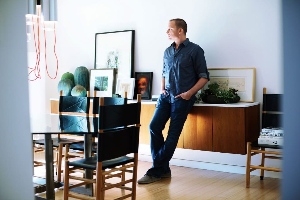 Joshua Rice in his dining room. Vintage Scarpa dining table and Kentucky dining chairs by Carlo Scarpa; the latter were designed for Bernini. Lantern light-fixture set by Mathias Hahn for Ligne Roset. Artwork behind plants by
Lorraine Tady, from Barry Whistler Gallery.