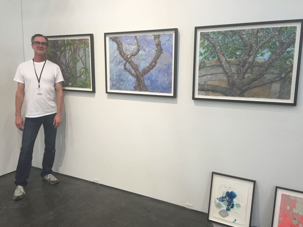 Inman Gallery goes with a conceptual landscape theme. Director Patrick Reynolds poses with a wall of Beth Secor paintings.