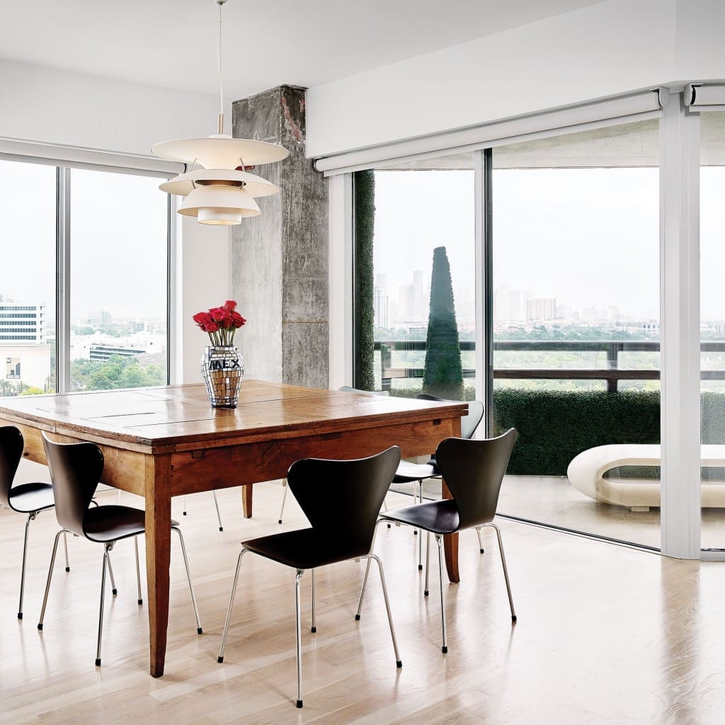 In the dining room, antique Italian walnut table from Chateau Domingue. Arne Jacobsen Series 7 chairs. Louis Poulsen lighting pendant. Vase is a flea-market find from Santa Fe.