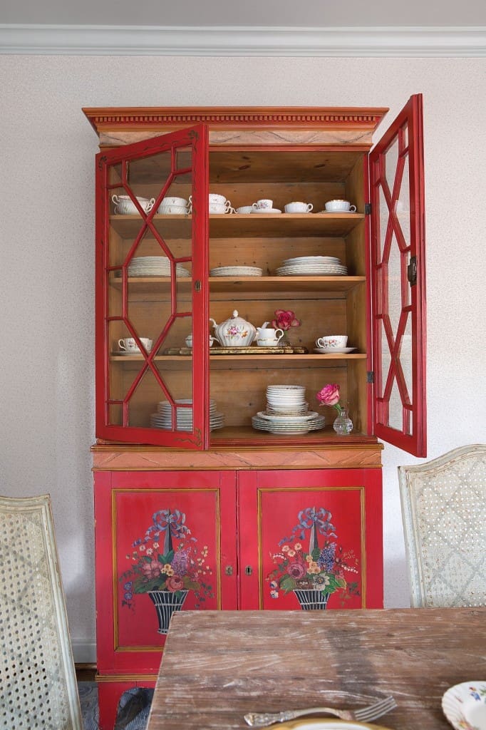 Looke isn’t normally into red but embraced this family antique china cabinet, which proved just the dash she needed for the serene blue dining room.
