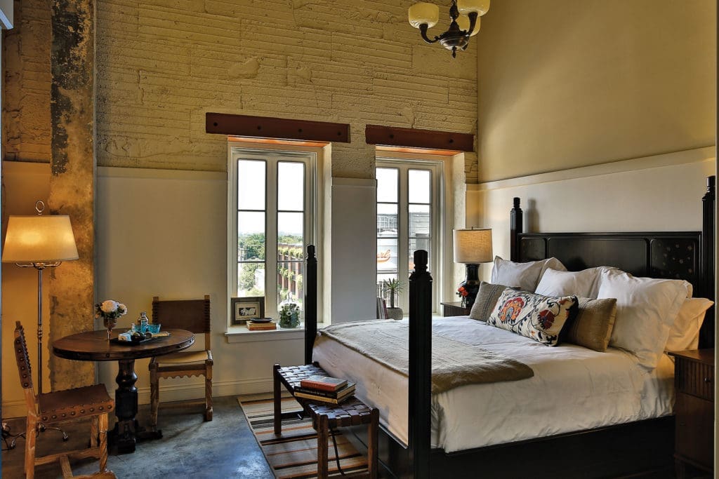 One of Hotel Emma's 146 rooms with a glazed black bed inspired by the artistry of the Herter Brothers
