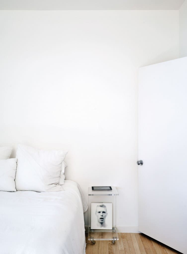 In Davis’ bedroom, white is the leitmotif. The space
is painted in the cloud-like shade of Silver Lining by
Pratt & Lambert. “I consulted with designer Margaret
Naeve of M. Naeve regarding the intimate details of
the space,” says Davis. The nightstand is an acrylic
C table. Bedside reading is a volume on artist Bill Jacobson, its cover one of the photographer’s eerie early-1990s portraits that reference the AIDS crisis.