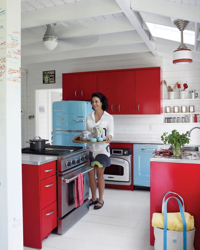 Poppi Massey in her Nantucket
kitchen with stainless-steel cabinets by St. Charles Cabinetry and a Big Chill refrigerator.