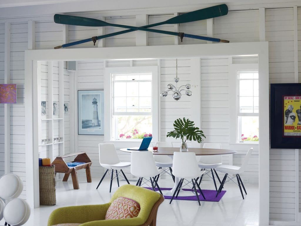 In the dining room, Saarinen table and Eames Eiffel chairs from Inmod. Purple rug from Flor. The print of Sankaty Head lighthouse came with the house. Far right, a poster from an art opening that Andy Warhol and Jean-Michel Basquiat designed together.
