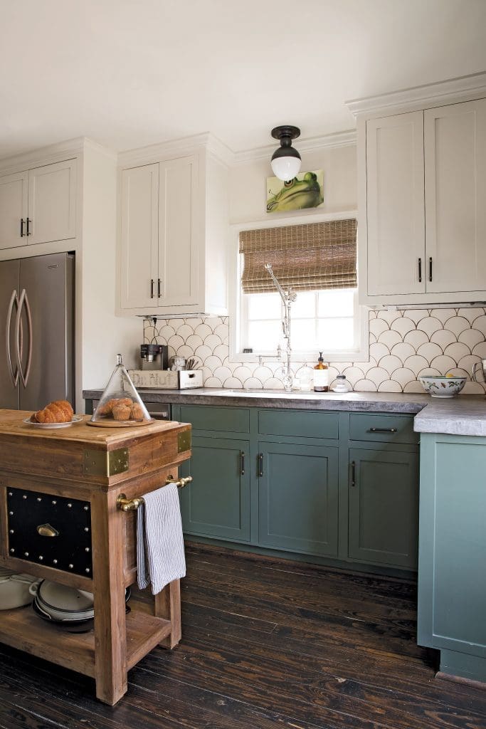 Barton fully renovated the kitchen with two-tone cabinets (lowers in Sherwin Williams Rosemary; uppers in Benjamin Moore Hazy Skies) and concrete counters with Tabarka Studio’s hand-painted terra-cotta tile backsplash.