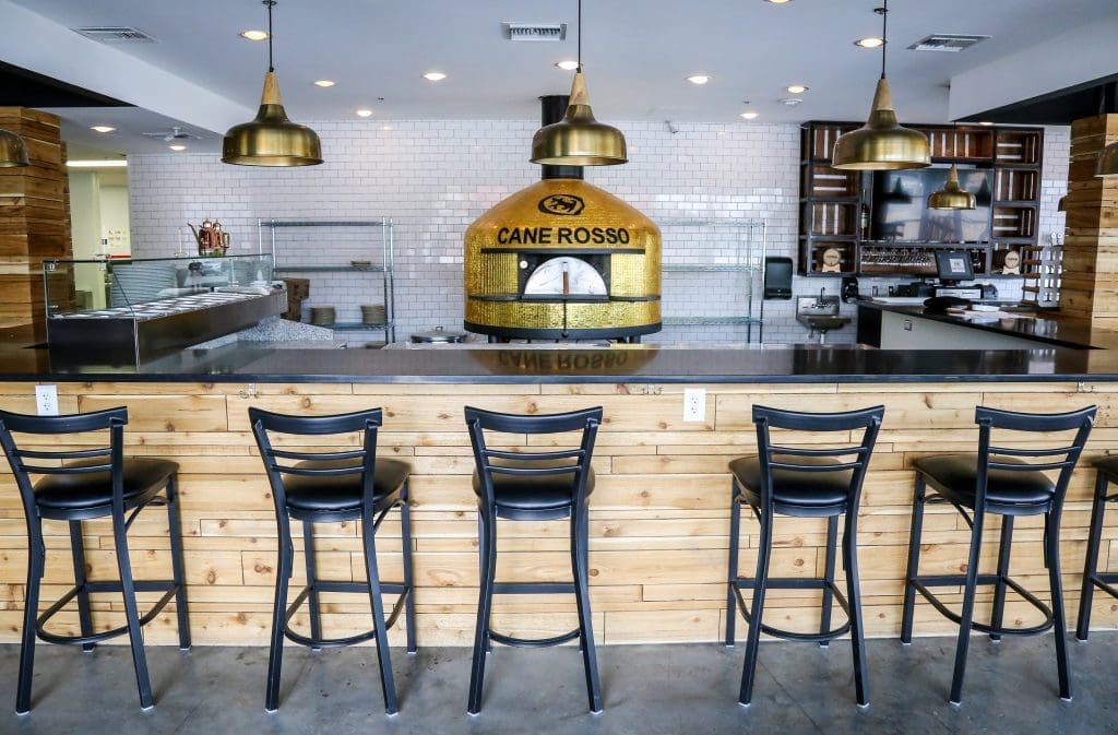 The gold-tiled Stefano Ferrara pizza oven sits front and center amid Cane Rosso's pizza bar. 