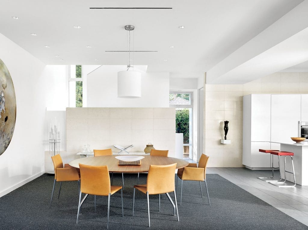 Walnut table by German manufacturer Wilkhahn, with vintage Zanotta leather chairs from Kuhl-Linscomb. Mies van
der Rohe stools in the kitchen were originally designed for the Four Seasons restaurant in NYC. The commissioned round painting is Darren Waterston’s Tondo, 2013, from Inman Gallery. Bronze figure is by Mario Korbel, 1923. A
partial wall made from Parisian limestone hides a staircase in the entry.