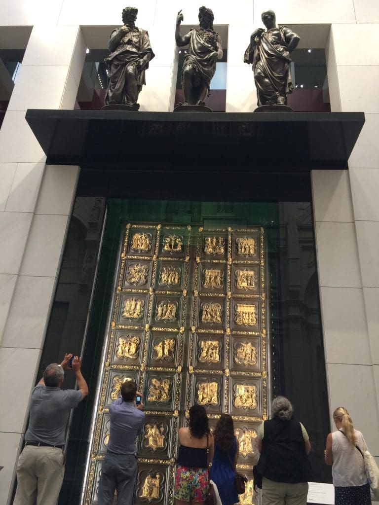 Tourists photograph Ghiberti's original Door of Paradise in the Duomo Museum.