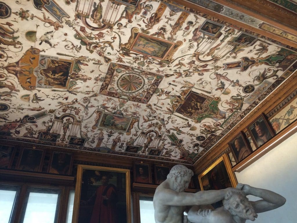 Below the elaborate ceilings are sculptures and framed portraits. 