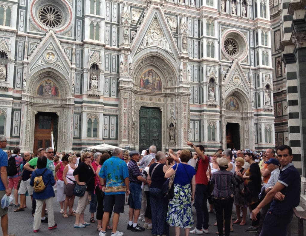Tourists converge near the steps of the Duomo.