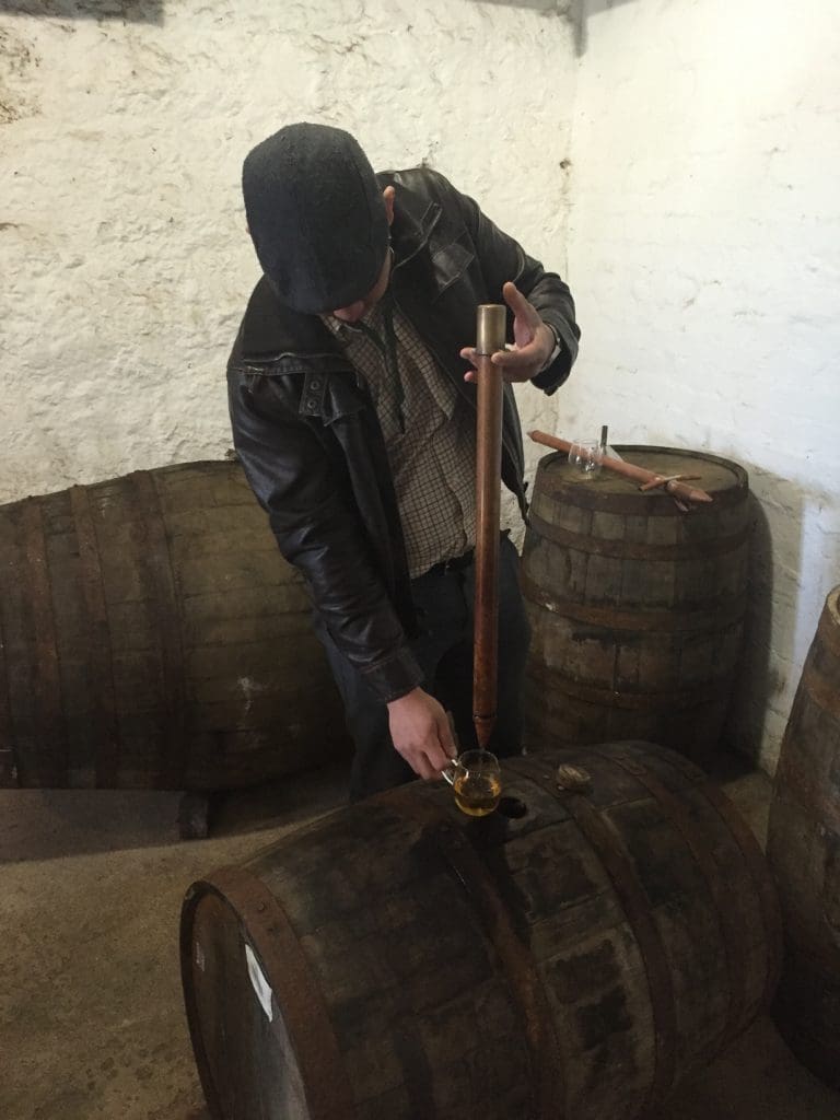 Jessey Qi tasting from the barrel at Laphroaig. (Photo by Bobby Heugel)