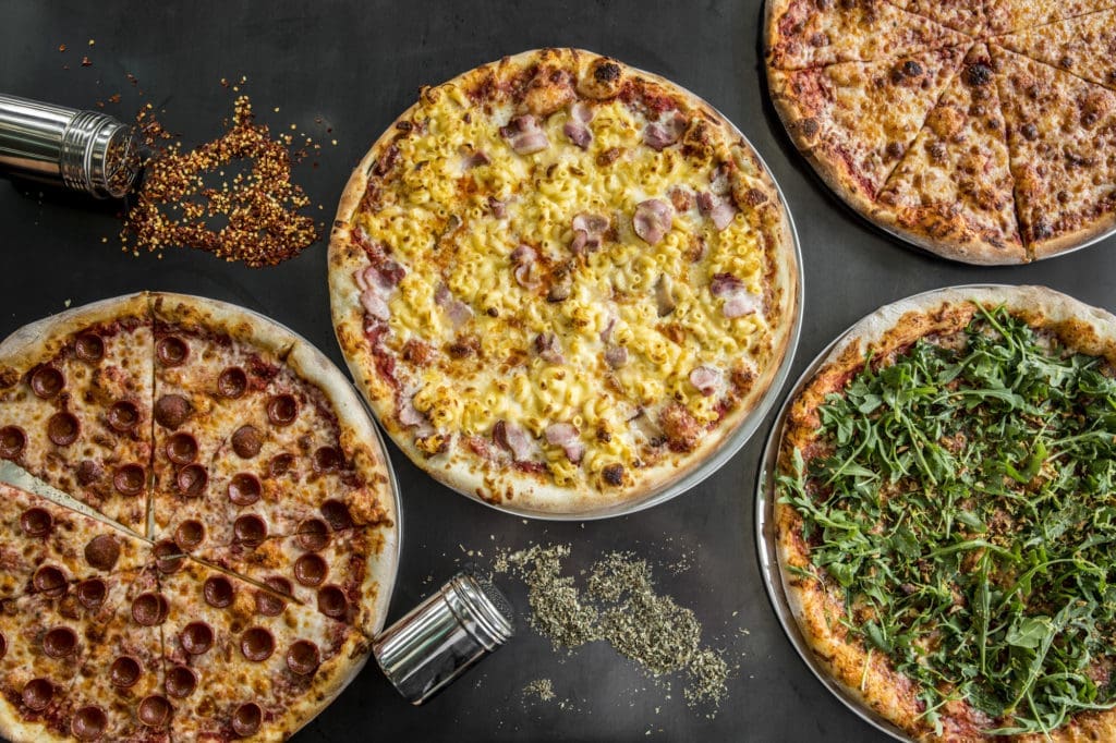 Assorted pizzas from Pi Pizza, with Who's the Mac in the center. 