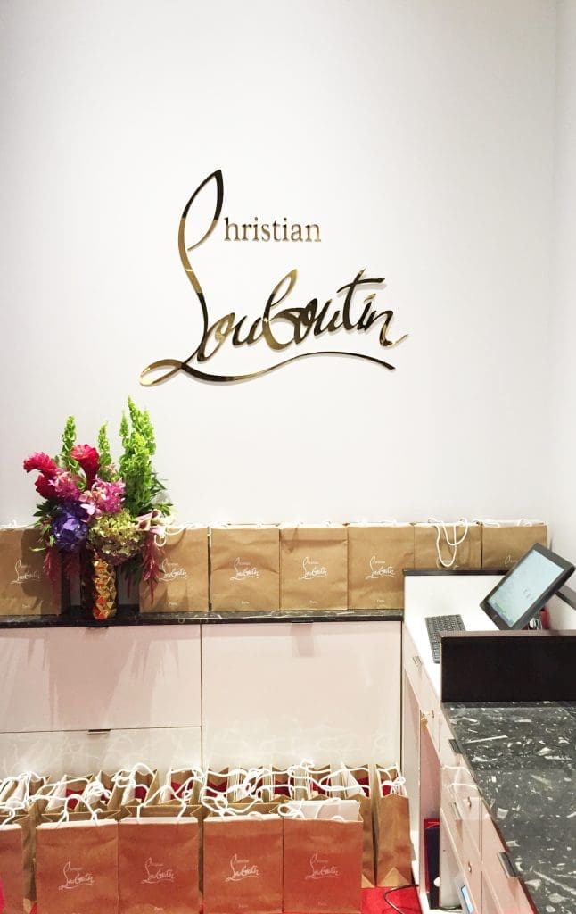 The Christian Louboutin logo is embossed behind counter. 