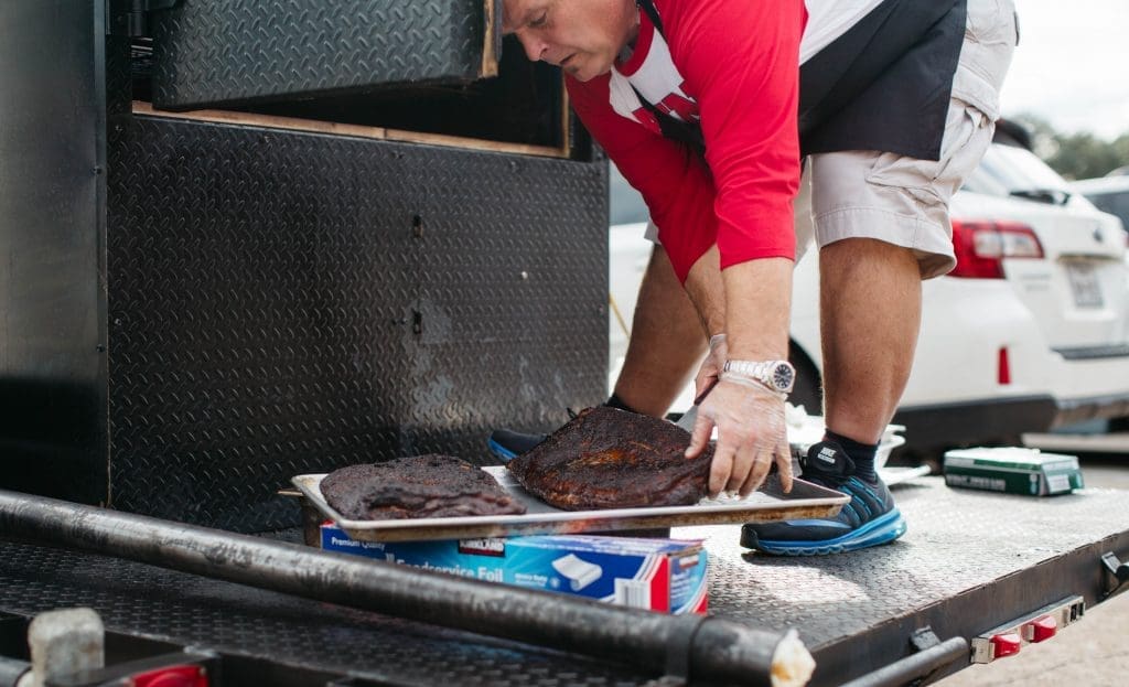 Barbecue king Ronnie Killen loads meat into the portable smoker. 