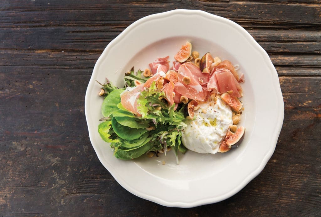 Relish's fig salad features burrata, sliced proscuitto, toasted hazelnuts, watercress, and a lemon, maple vinaigrette. 