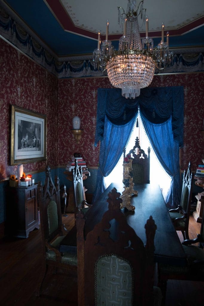 Dining-room chandelier from a Dallas estate. Period American Gothic chairs in Donghia fabric. Antique table was a flea-market find. Gustav Carroll candlesticks.