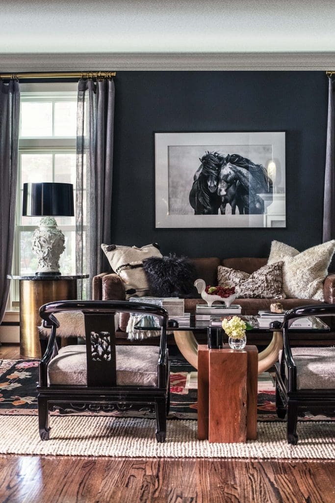 In the living room, a Roberto Dutesco photograph from “The Wild Horses
of Sable Island” series. Tusk table, a vintage Thrift Studio fi nd. Vintage
lacquered chairs. Porcelain lamps from Mercury Design Studio, Austin.
Art of Old India rug. Custom brass-and-black-marble side tables from
Scout Design Studio. Walls painted in Behr’s Cracked Pepper.