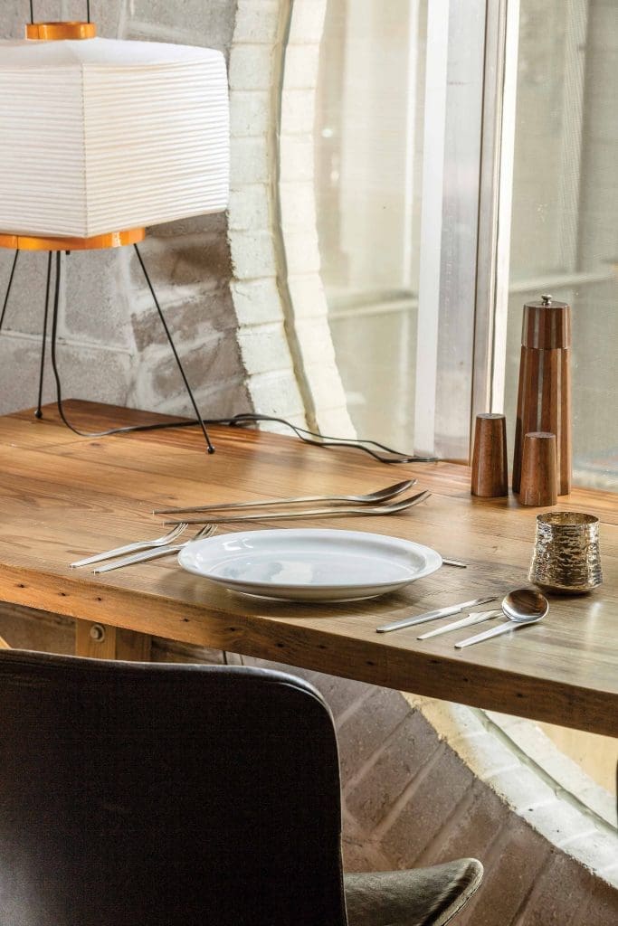 The kitchen table designed by Zemanek from salvaged wood from the previous home on the lot, Arne Jacobsen flatware, Tapio Wirkkala hand-hammered sterling silver cup, and a Paul
Evans and Phillip Lloyd Powell shaker set.