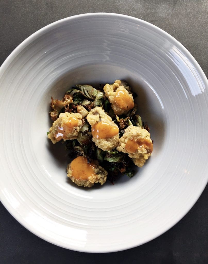 Get your seafood fixe with Field & Tides' fried oysters and Brussels sprouts served with a chili honey glaze. 