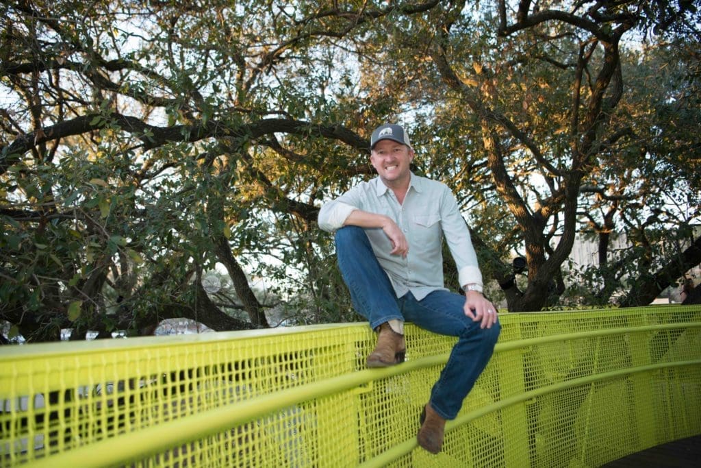 Chef Tim Love sits on a bridge in the Houston's Levy Park.