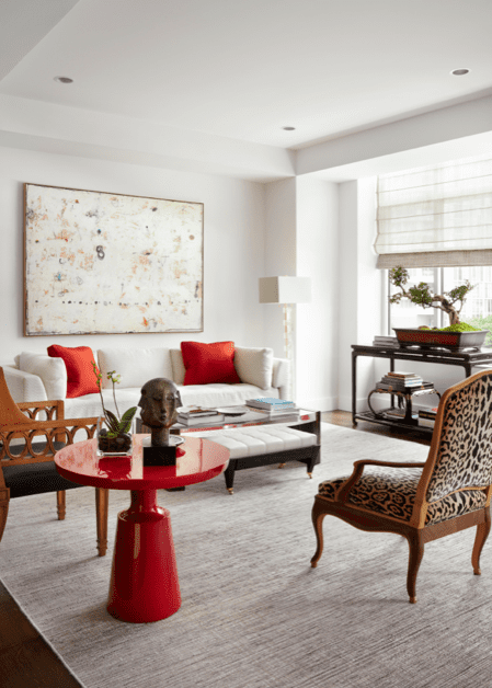 In the living room, a Cameron sofa upholstered in David Gibson fabric with Hermès pillows, and a Cameron table and bench, from George Cameron Nash. Holly Hunt lacquer table. Rose Tarlow Melrose House prototype chair. Yale R. Burge prototype chair upholstered in Clarence House leopard velvet. Antique Chinese console holds a 75-year-old Fukien Tea bonsai. Painting by Belgian artist Cole Morgan.