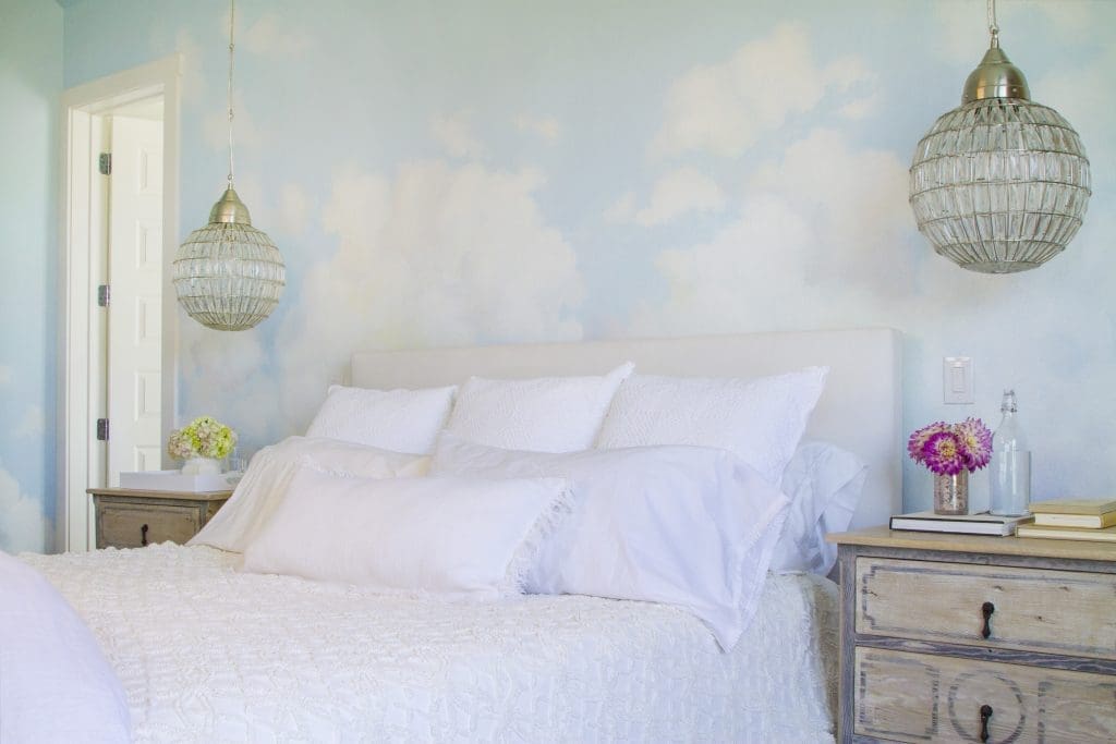 In the master bedroom, custom hand painted cloudscape by Peggy Jones; Wisteria Montgolfier chandeliers; Dressers by Customfurniturela; Room & Board Wyatt California King Bed in Sunbrella canvas white fabric. (Photo by Manny Rodriguez)