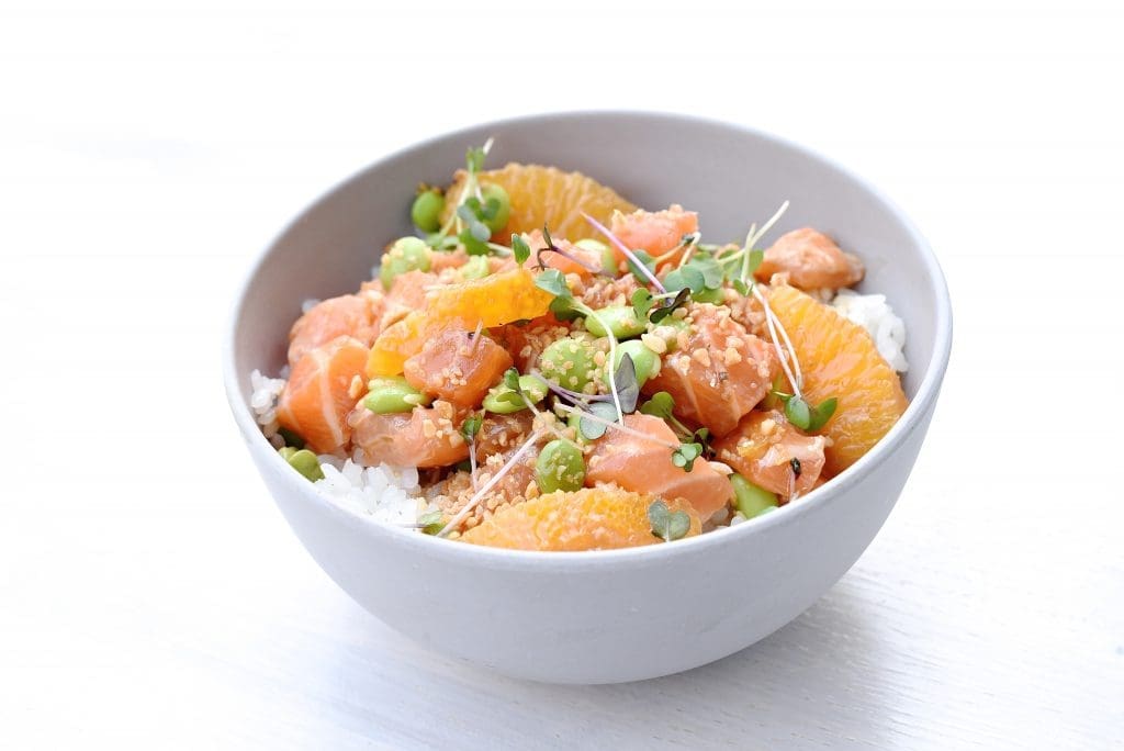 The salmon ponzu bowl at Seaside Poke is dressed with ponzu, orange, edamame, and garlic. 