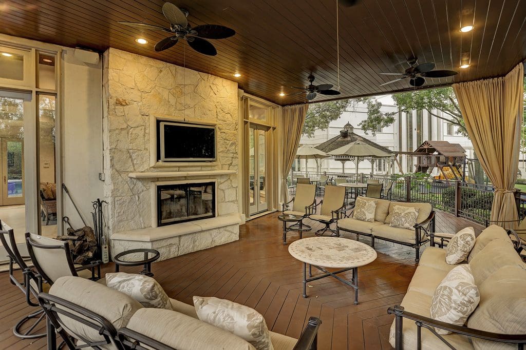 The tranquil outdoor living area features a wood-burning gas quarried-stone fireplace with cast stone mantle piece and elevated hearth.