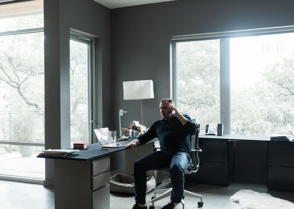 The author retrofitted filing cabinets with custom-made desktops enveloped in black-billiard felt to create an expansive, functional workstation. Herman Miller filing cabinets and Setu Chair. Model BB3/X3 floor lamp by Noguchi.