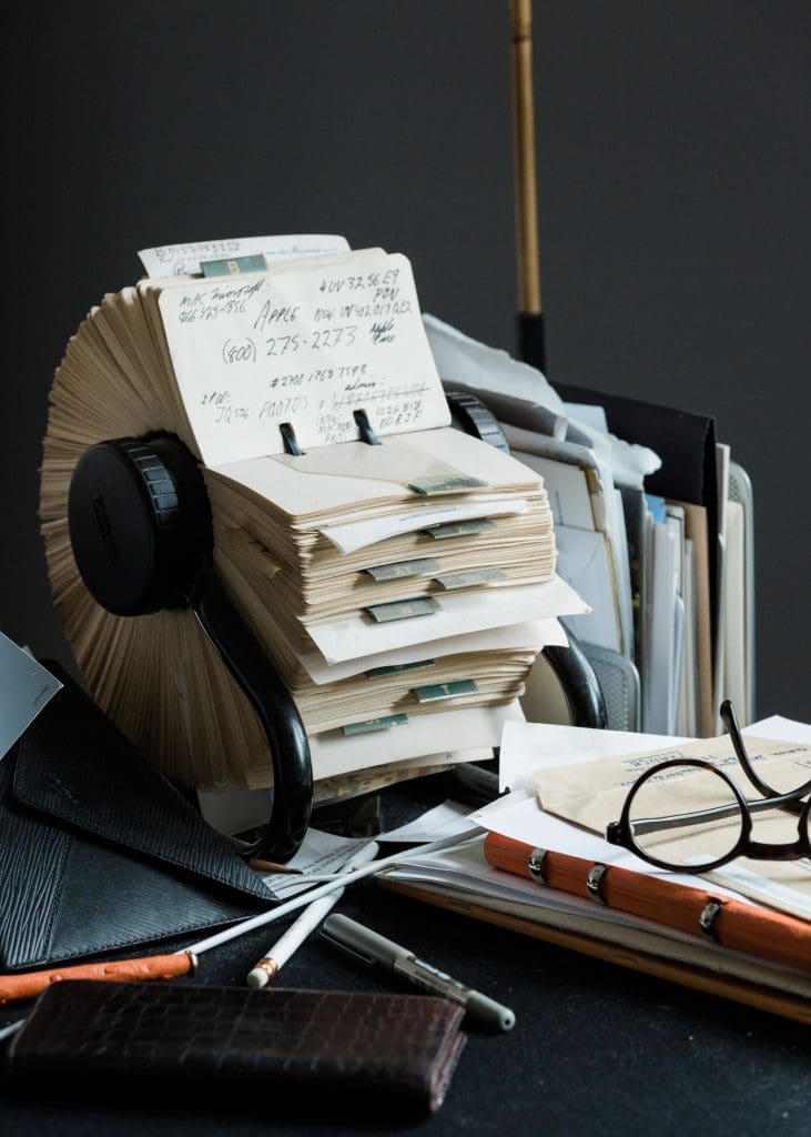 Desk corner with alligator Alexandra Knight magnifying glass (a gift from Lynn Wyatt), custom-made glasses by Maison Bonnet in Paris, a Louis Vuitton alligator agenda, and well-thumbed Rolodex. (Photo by Max Burkhalter)