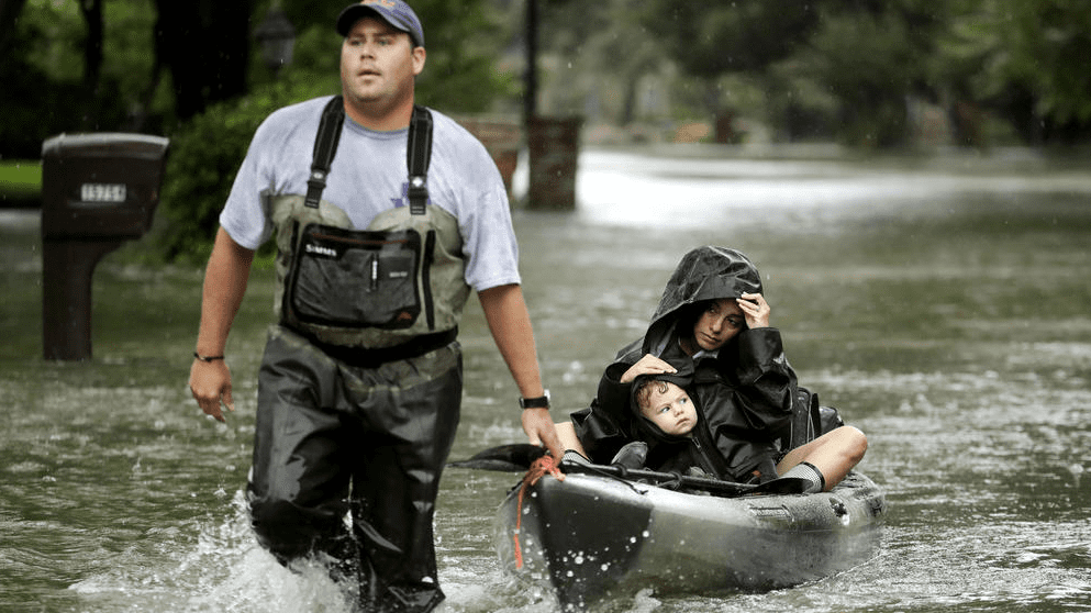 Volunteer helps rescue residents from West Houston neighborhood. (Photo by Charlie Riedel / AP) 