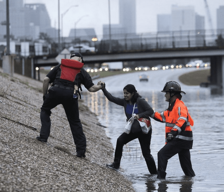 Woman rescued by first responders from flooding freeway. 