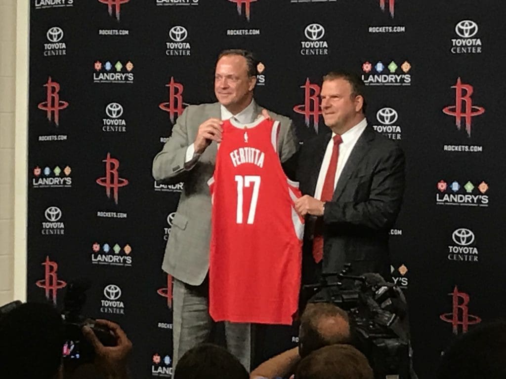 Rockets CEO and Tilman Fertitta pose with Fertitta's new jersey in 2017 on his first official day as the Houston Rockets new owner.