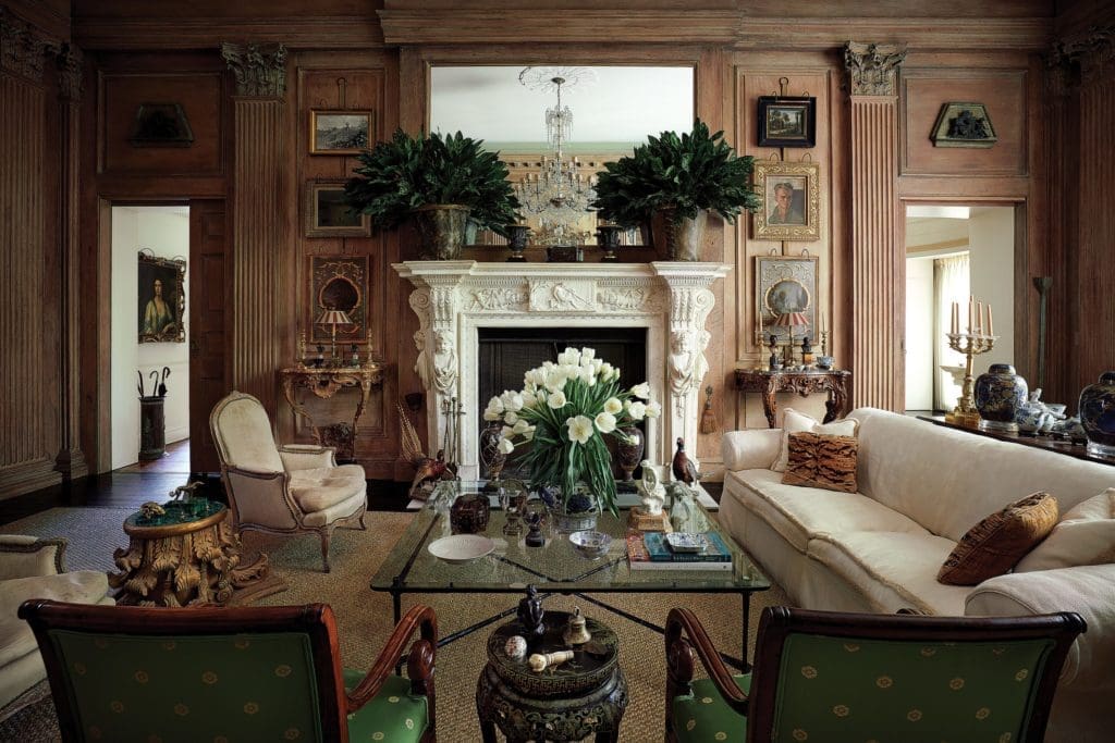 The oak drawing-room paneling, pilasters, capitals and marble mantel all date from 1729, salvaged from Wingerworth Hall, Derbyshire, England. Iron-and-glass table from Minton-Corley collection. 