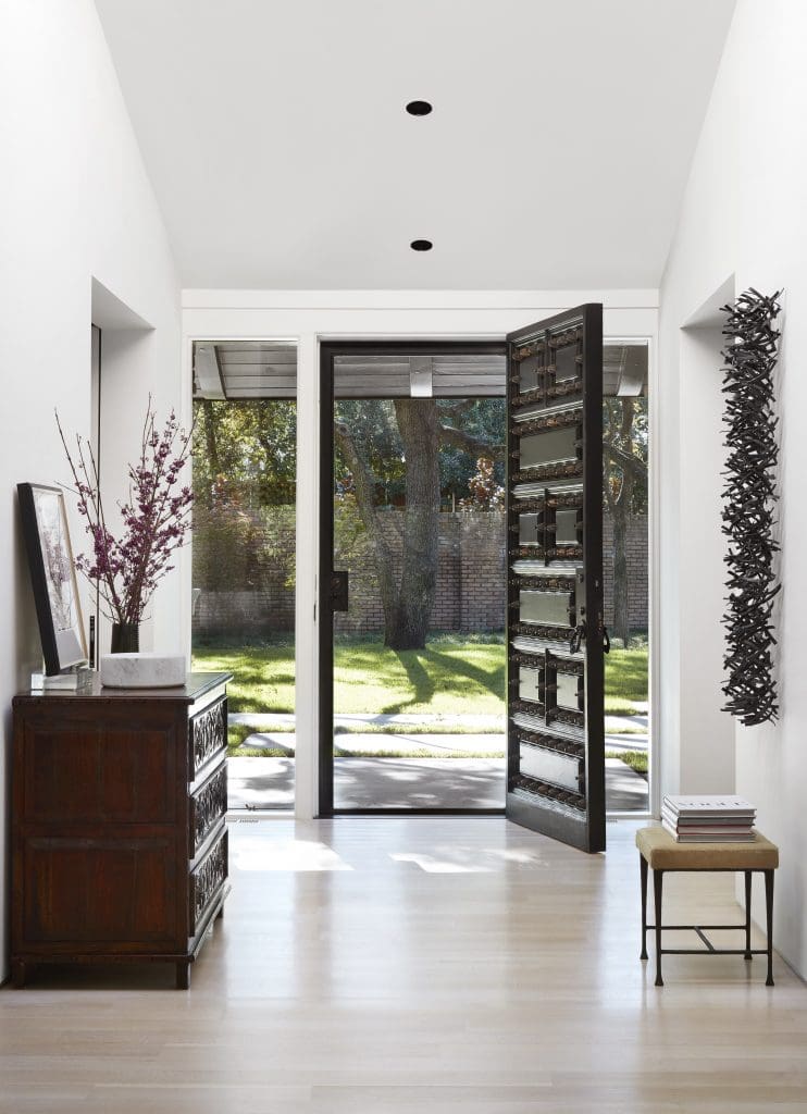 The monumental carved front door is original to the house. Wall sculpture, Matt Devine’s The Wake, 2012. Christian Liaigre bench in Jerry Pair cowhide. Vintage chest.