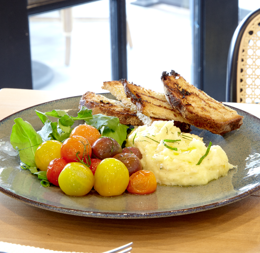 The brandade, a popular appetizer, consists of salt cod, potato, spicy blistered tomatoes, mint, and toasted baguette