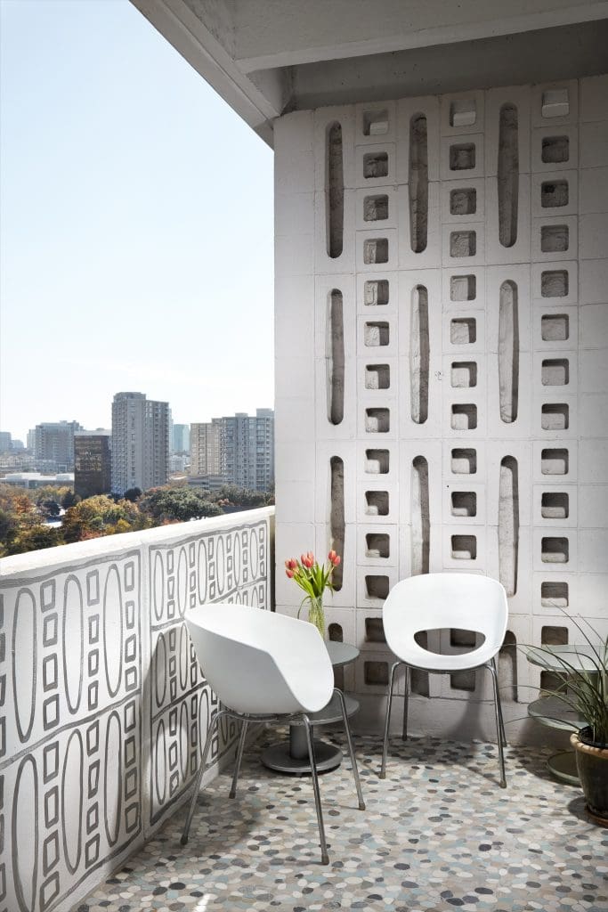 George Dahl’s concrete partition exterior wall, 1964. Pam Nelson painted the balcony wall with silver metallic paint, referencing Dahl. Cantoni chairs. Floor is sliced pebble mosaic stone tiles from Floor & Decor.