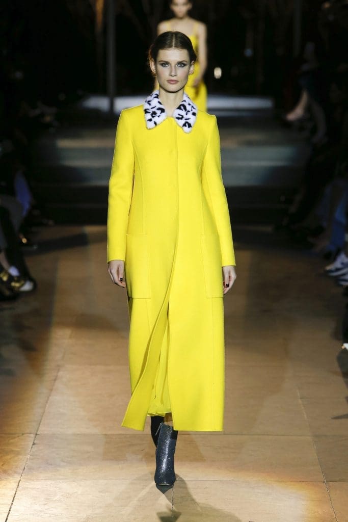 Carolina Herrera long yellow coat with black and white fur collar.