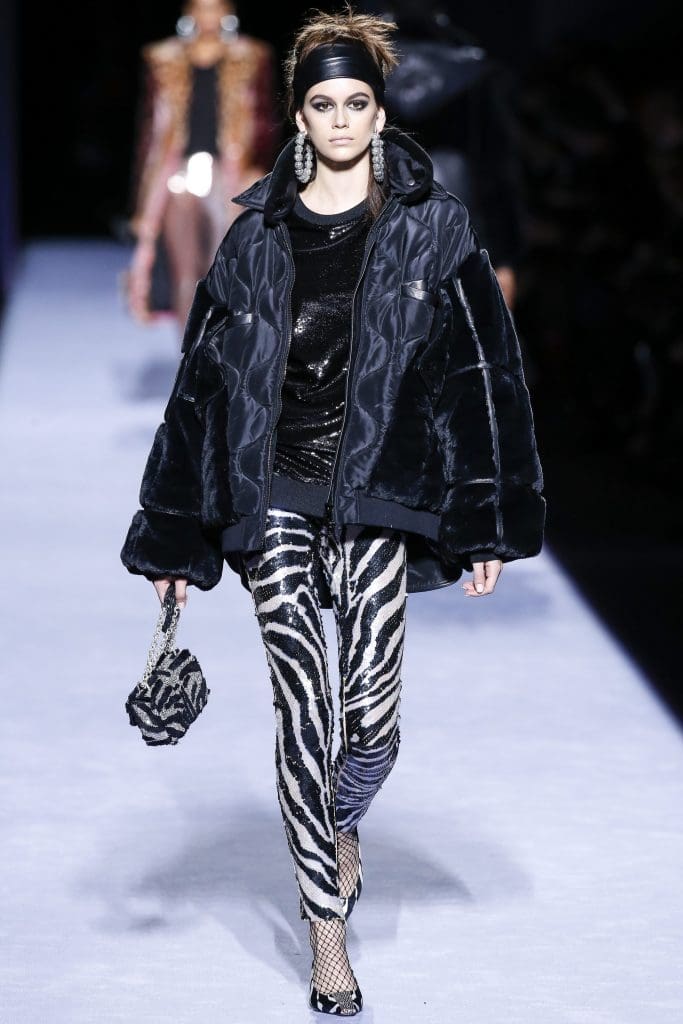 Model-of-the-moment Kaia Gerber, the daughter of Cindy Crawford, channels the '80s in sequined zebra-print leggings, oversized jacket, and hoop earrings.