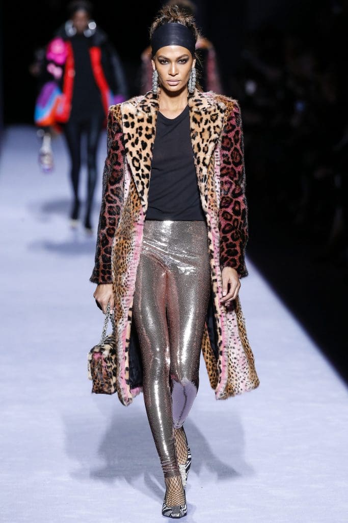 Model Joan Smalls in a leopard print coat, silver leggings and black top, with matching leopard print  handbag — all from the Tom Ford fall 2018 collection.