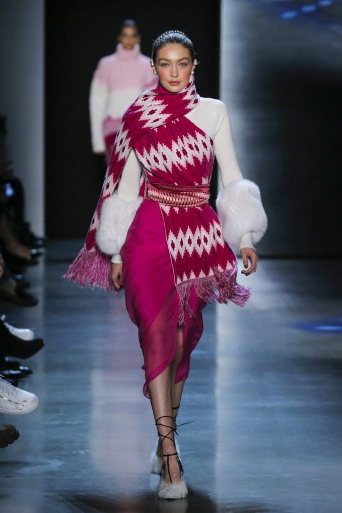Prabal Gurung porcelain cashmere turtleneck sweater with fox fur trim, orchid silk crepe back satin skirt with silk sarong chiffon draped overlay, orchid multi-engineered mandala stripe wool knit scarf with fringe.