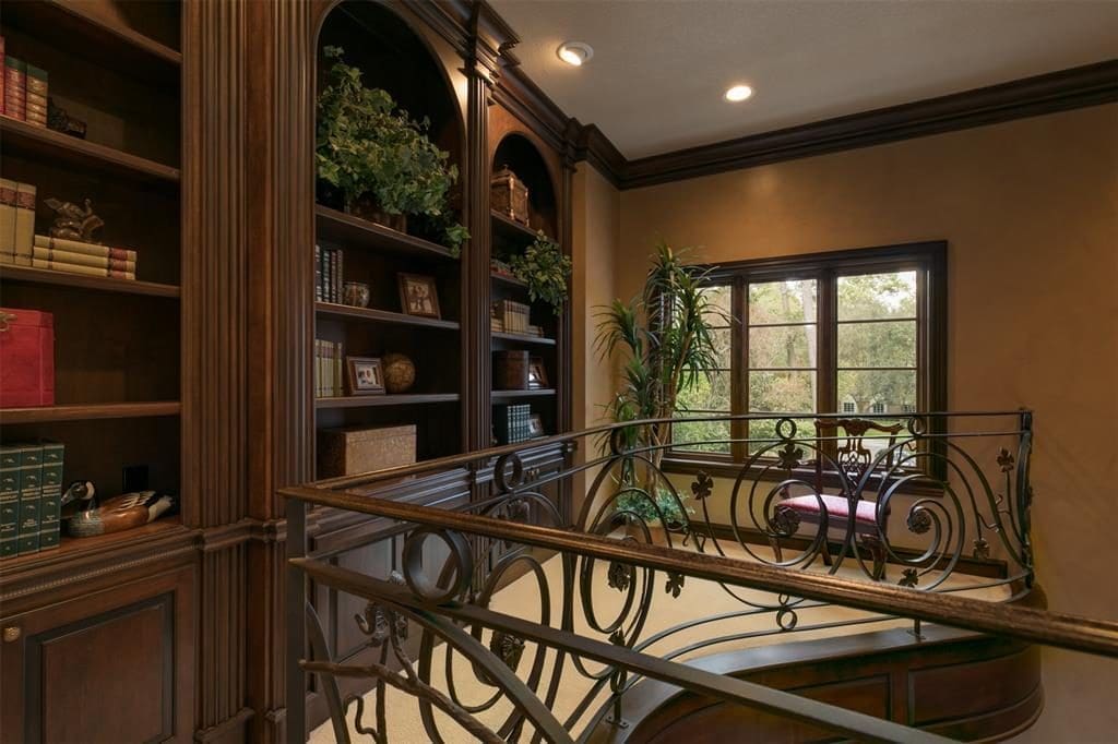 The upper study shares many elements with the lower study and has its own flair, with a wrought iron hand rail. 